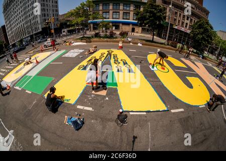 Lokale Künstler malen am Samstag, 4. Juli 2020, ein massives Wandgemälde „Black Lives Matter“ auf dem Adam Clayton Powell Blvd in Harlem in New York. (© Richard B. Levine) Stockfoto