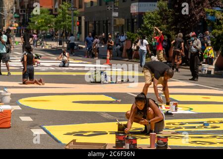 Lokale Künstler malen am Samstag, 4. Juli 2020, ein massives Wandgemälde „Black Lives Matter“ auf dem Adam Clayton Powell Blvd in Harlem in New York. (© Richard B. Levine) Stockfoto