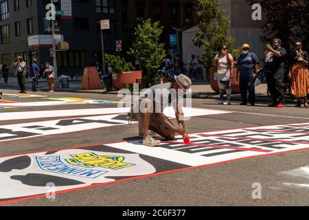 Der Künstler Guy Stanley Philoche arbeitet an seinen Briefen des massiven Wandbildes „Black Lives Matter“ am Adam Clayton Powell Blvd in Harlem in New York am Samstag, 4. Juli 2020. (© Richard B. Levine) Stockfoto