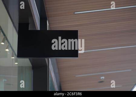 Blanker schwarzer Anbau des modernen Ladenschildes mit moderner Architektur und Glasfenstern. Leere Beschilderung nachmachen. Stockfoto