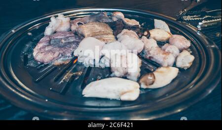 Nahaufnahme der Kittlinge mit Pilzen, die im koreanischen Restaurant gebraten werden Stockfoto