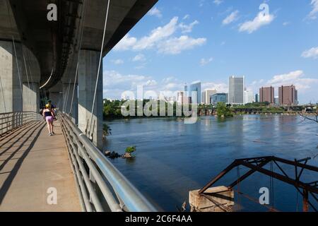 RICHMOND, VIRGINIA - 9. August 2019: Die Skyline von Richmond wird an einem Spätsommertag von der Belle Isle Hängebrücke aus über den James River gesehen Stockfoto