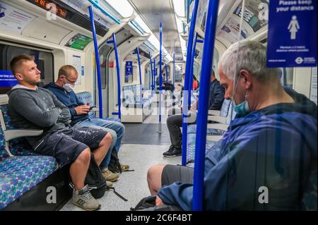 London, Großbritannien. Juli 2020. Die überwiegende Mehrheit der Reisenden trägt jetzt Masken, wie vorgeschrieben, aber es bleibt Minderheit, die diese Regel ignorieren. Die Passagierzahlen steigen, bleiben aber während der frühen Hauptverkehrszeit dramatisch zurück. Dies trotz der weiteren Lockerung der staatlichen Leitlinien. Wer reist, trägt fast alle Masken, nachdem sie im öffentlichen Verkehr obligatorisch werden. Die geschwächte „Sperre“ für den Coronavirus (Covid 19) Ausbruch in London weiter. Kredit: Guy Bell/Alamy Live Nachrichten Stockfoto