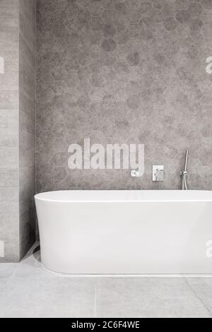 Modernes Bad mit Badewanne und Weiß Grau, sechseckigen Wandfliesen Stockfoto