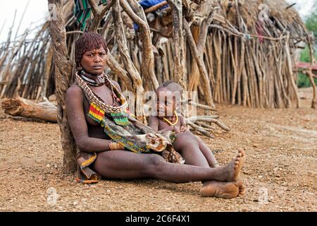 Schwarze Frau mit Kind des Stammes Hamar / Hamer im Dorf im Omo River Valley, Debub Omo Zone, Süd-Äthiopien, Afrika Stockfoto