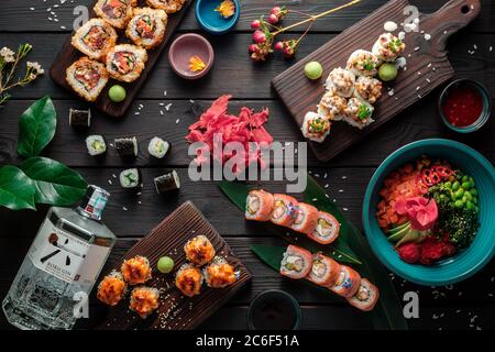 Tisch serviert mit Sushi, Brötchen und traditionellen japanischen Speisen auf dunklem Hintergrund. Draufsicht. Stockfoto