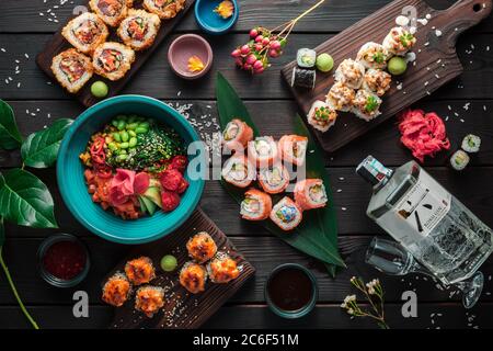 Tisch serviert mit Sushi, Brötchen und traditionellen japanischen Speisen auf dunklem Hintergrund. Draufsicht. Stockfoto