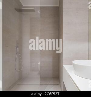 Elegantes Badezimmer in Beige mit moderner Dusche und Waschbecken Stockfoto