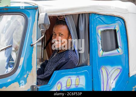 Schwarzer Taxifahrer lächelt in Tuk-Tuk / Auto Rikscha in der Stadt Awasa / Awassa / Hawassa, Great Rift Valley, Süd-Äthiopien, Afrika Stockfoto