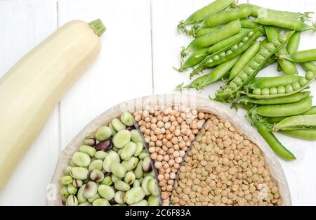 Eine vegetarische Proteinquelle sind Linsen, Erbsen, Kichererbsen und Bohnen. Draufsicht auf einem weißen Tisch. Stockfoto