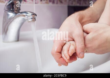 Kind wäscht Hände in Waschbecken. Wasserstrahl aus dem Wasserhahn. Desinfektion der Hände mit Wasser. Virenschutz. Konzept der Händewaschen, Hygiene. Coronavirus c Stockfoto