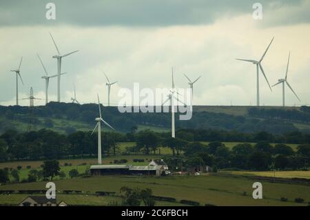 Larkhall, Schottland, Großbritannien. Juli 2020. Im Bild: Eine riesige Windkraftanlage steht ein paar hundert Meter hoch, während ihre Klingen auf dem Boden liegen bereit, befestigt werden. Grüne Energie ist ein großes Geschäft, und wenn Großbritannien seine Ziele für erneuerbare Energien archivieren soll, müssen mehr Windenergieanlagen an Land und auf See gebaut werden. Quelle: Colin Fisher/Alamy Live News Stockfoto