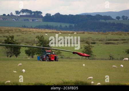 Larkhall, Schottland, Großbritannien. Juli 2020. Im Bild: Eine riesige Windkraftanlage steht ein paar hundert Meter hoch, während ihre Klingen auf dem Boden liegen bereit, befestigt werden. Grüne Energie ist ein großes Geschäft, und wenn Großbritannien seine Ziele für erneuerbare Energien archivieren soll, müssen mehr Windenergieanlagen an Land und auf See gebaut werden. Quelle: Colin Fisher/Alamy Live News Stockfoto