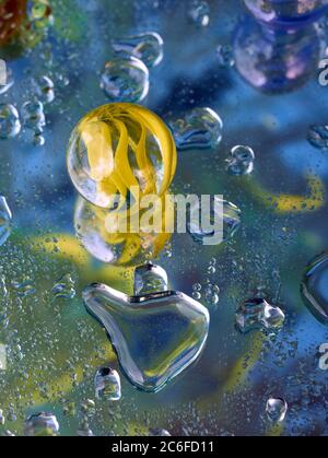 Single Glas Marmor und Reflexion mit einer Farbe infundiert Hintergrund und Wassertropfen, Blasen, Einsamkeit. Stockfoto