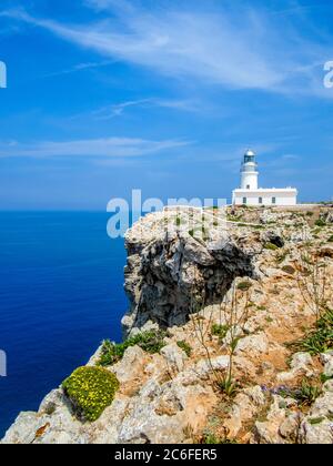 Idyllischer Blick auf den Leuchtturm des Kaps cavalleria vor steilen Klippen am mittelmeer bei es mercadal, menorca Stockfoto