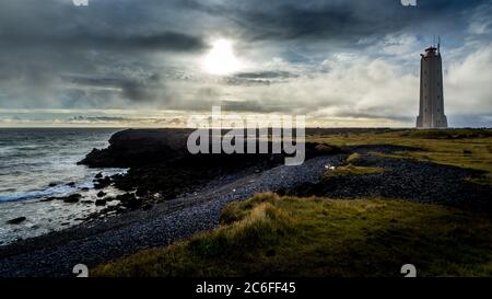 Dramatischer Himmel mit einer einsamen, nicht erkennbaren Person in der Ferne am Leuchtturm Malarrif auf der halbinsel snaefellsnes im Westen islands Stockfoto