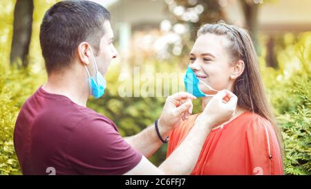 Glückliches Paar Entfernen von Schutzmaske Gesicht nach Coronavirus Lockdown wieder öffnen Stockfoto