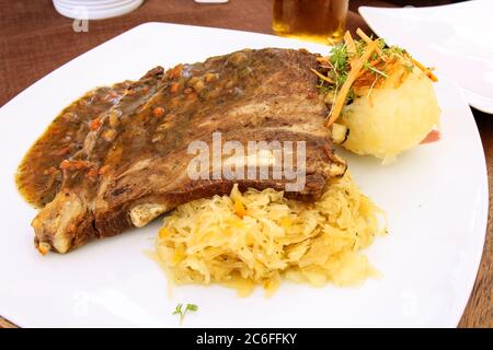 Traditionelle deutsche Küche: Spareribs aus Schweinefleisch mit Sauerkraut und Kartoffelknödel Stockfoto