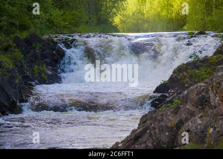 Die obere Schwelle des Kivach-Wasserfalls schließt sich an einem sonnigen Juni-Abend. Karelien, Russland Stockfoto