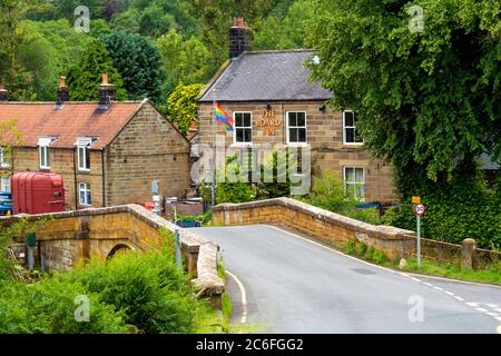 Der Vorstand Inn in Lealholm North Yorkshire aus gesehen auf der anderen Seite des Flusses Esk Stockfoto