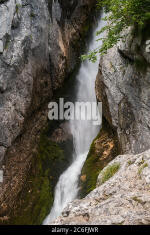 Kleine Wasserfallschlacht an der Quelle des Flusses Soca in den Felsen des Trentatals im Triglav Nationalpark Sloweniens. Stockfoto