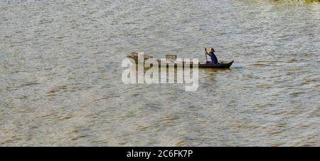 Mann rudert auf dem Yangon-Fluss, mit dem er Waren herumgefahren hat, Mayanmar, Asien Stockfoto