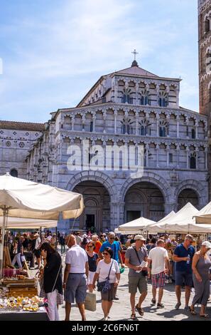 Lucca, Italien - 17. August 2019: Ein Spaziergang von Touristen und Einheimischen auf dem Flohmarkt vor der Kathedrale San Martino im historischen Zentrum von Lucca
