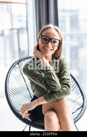 Junge Frau, die sich zu Hause im Schaukelstuhl ausruht Stockfoto