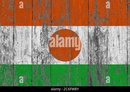 Niger Flagge auf grunge zerkratzte Holzoberfläche. Nationaler Vintage Hintergrund. Alte Holztisch zerkratzt Flagge Oberfläche. Stockfoto