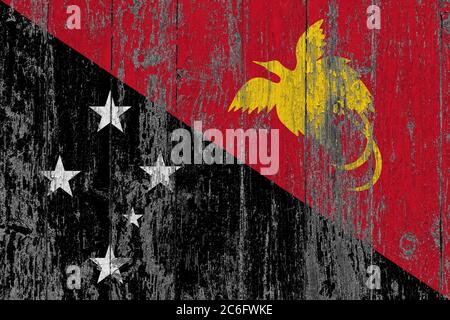 Papua-Neuguinea-Flagge auf Grunge zerkratzte Holzoberfläche. Nationaler Vintage Hintergrund. Alte Holztisch zerkratzt Flagge Oberfläche. Stockfoto