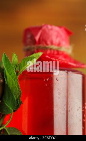 Dufttes Rosenwasser. Aroma Rosenwasser für die Hautpflege. Flasche enthält Rosenwasser und Rosenblätter Stockfoto