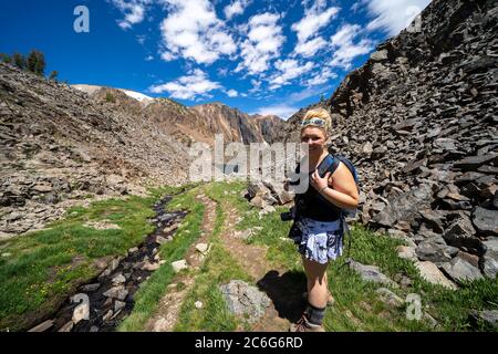 Junge erwachsene Frau Wanderer Spaziergänge entlang der Schmutz weg durch die Berge im Osten der Sierra Nevada, 20 Seen Trail Stockfoto