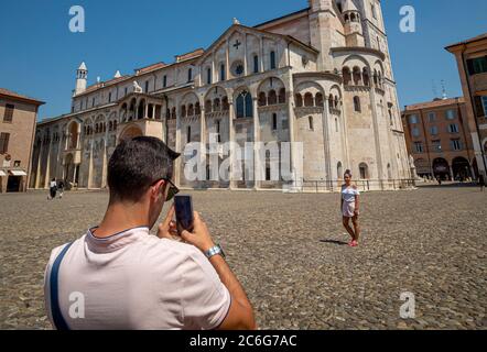 Mann, der ein Foto vor dem Duomo di Modena von der Piazza Grande aus gemacht hat. Modena, Italien. Stockfoto