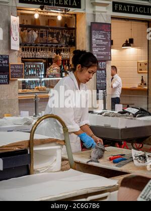 Weibchen, die einen Fisch auf dem Mercato Albinelli, Modena, Italien, ausstreckten. Stockfoto