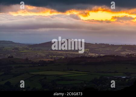 Askerswell, Dorset, Großbritannien. Juli 2020. Wetter in Großbritannien. Blick vom Eggardon Hill bei Askerswell in Dorset Blick auf Lewesdon Hill als Pause in der dunklen launischen Wolken leuchten orange bei Sonnenuntergang. Bildquelle: Graham Hunt/Alamy Live News Stockfoto