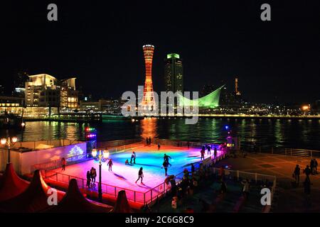 Kobe Port Tower und Kobe Maritime Museum bei Nacht mit Eislaufen im Vordergrund. Stockfoto