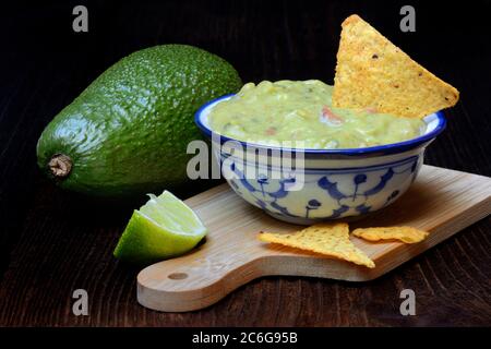 Schale mit Guacamole, Avocado, Limette und Tortilla Chips, Deutschland Stockfoto
