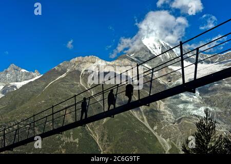 Wanderer im Rücklicht auf der Charles Kuonen Hängebrücke, Randa, Wallis, Schweiz Stockfoto