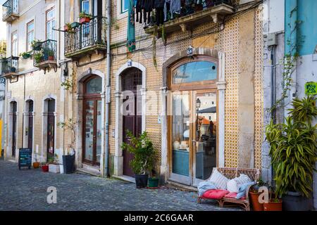 Blick auf die Straße auf die Geschäfte und alten Gebäude im Stadtteil Alfama von Lissabon Stockfoto