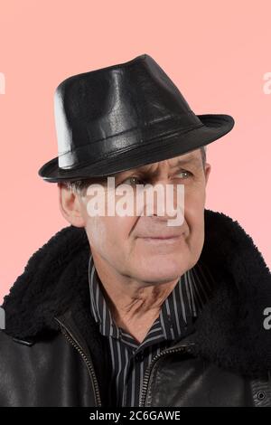 Älterer Mann mit Lederhut und Jacke Stockfoto