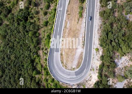 Luftaufnahme der kurvenreichen Straße in hohen Bergpass durch grüne Kiefernwälder. Hochwertige Fotos Stockfoto