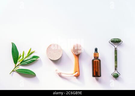 Moderne Apotheke, natürliche Zutaten. Öl aus Kräutern, Lavendelseife, Gesichtswalze und Holzbürste, Draufsicht, Flachlage, Kopierraum. Stockfoto