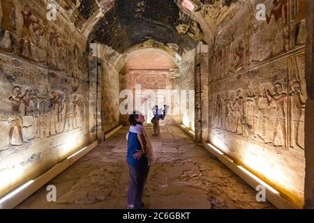 Touristen in Ehrfurcht vor den Reliefs an den Wänden der Kapelle gewidmet Amun Re im Tempel von Seti I in der Abydos-Komplex Stockfoto