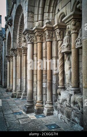 Basilika Saint Sauveur, Dinan, Bretagne, Frankreich, Europa. Detail des romanischen Eingangs. Säulen und beschädigte Skulpturen sind sichtbar. Stockfoto