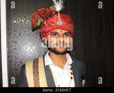 Indischer Bräutigam in traditioneller Kleidung mit buntem Turban-Porträt, selektiver Fokus mit Unschärfe. Stockfoto