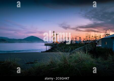 Sonnenuntergang über Booten, die im Hafen von Port Orford festgemacht sind. Stockfoto