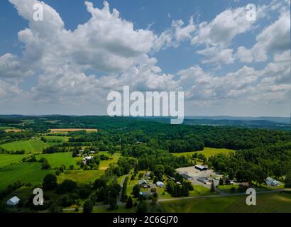 Bauernhof Felder Blick von oben gepflanzt in der Nähe der Berge Wälder blauer Himmel weiße Wolken Hintergrund Panorama Stockfoto