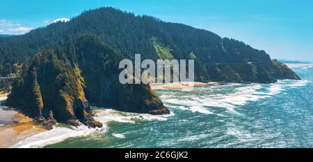 Luftaufnahme des Pazifischen Ozeans in Oregon, Highway 101 schlängelt sich durch Berge. Stockfoto