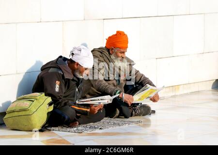 Zwei indische sikhs mans sitzt nahe dem Wasser des goldenen Tempels. 03 Dezember 2019 Amritsar, Punjab, Indien. Stockfoto