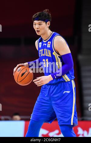 Der chinesische Profi-Basketballspieler Wang Zhelin von Fujian SBS Xunxing Sturgeons hält den Ball während eines Spiels in der ersten Stufe der chinesischen Basketballbahn Stockfoto